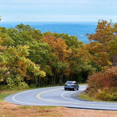 Car on a winding road through fall foliage